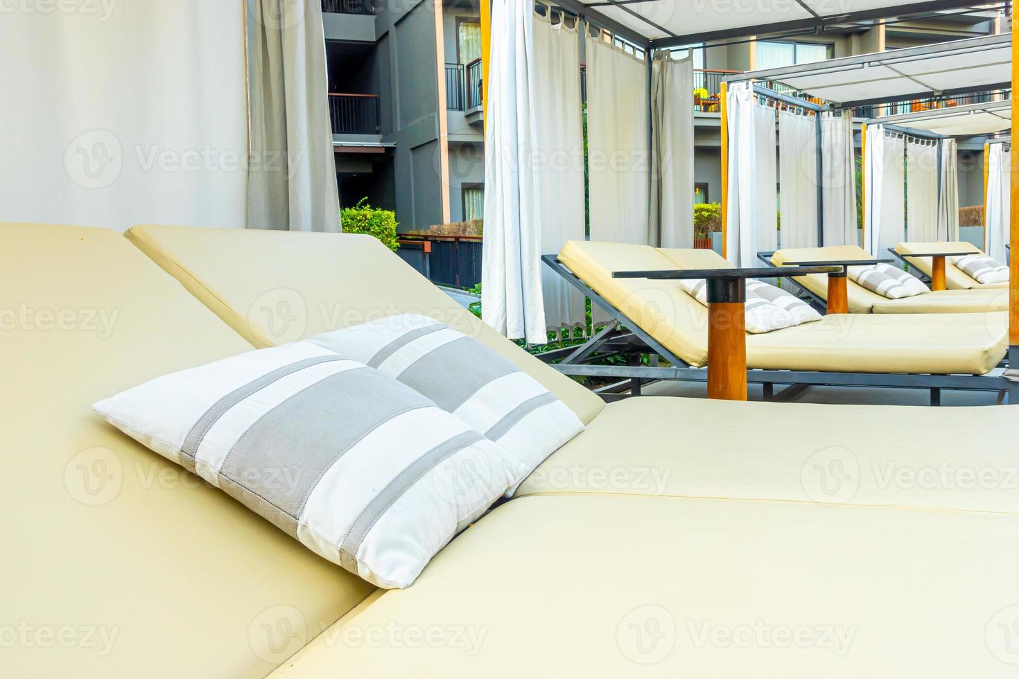 Sonnenschirm und Stuhlsofa rund um den Außenpool im Hotelresort für den Reiseurlaub? foto