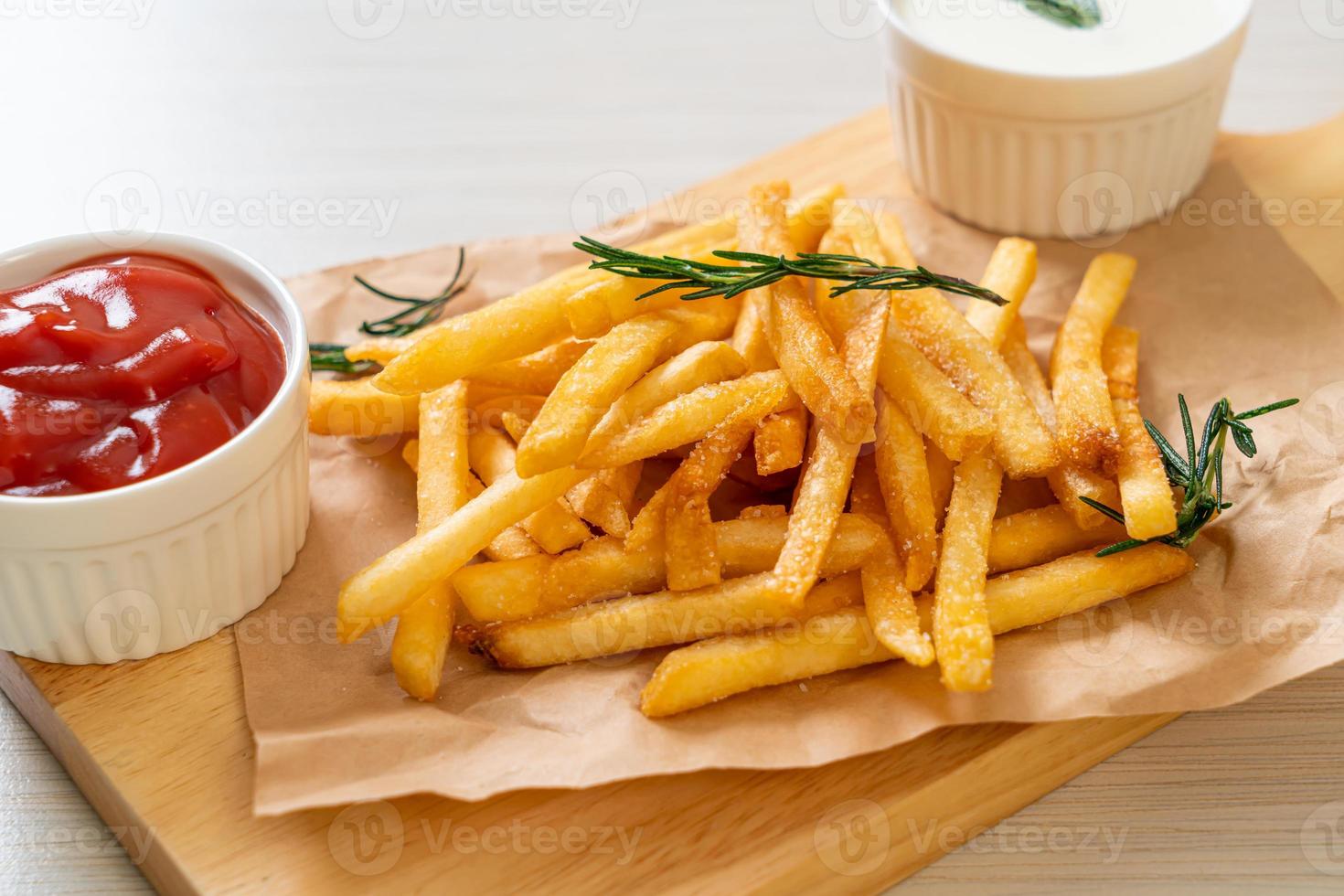 Pommes Frites mit Sauerrahm und Ketchup foto