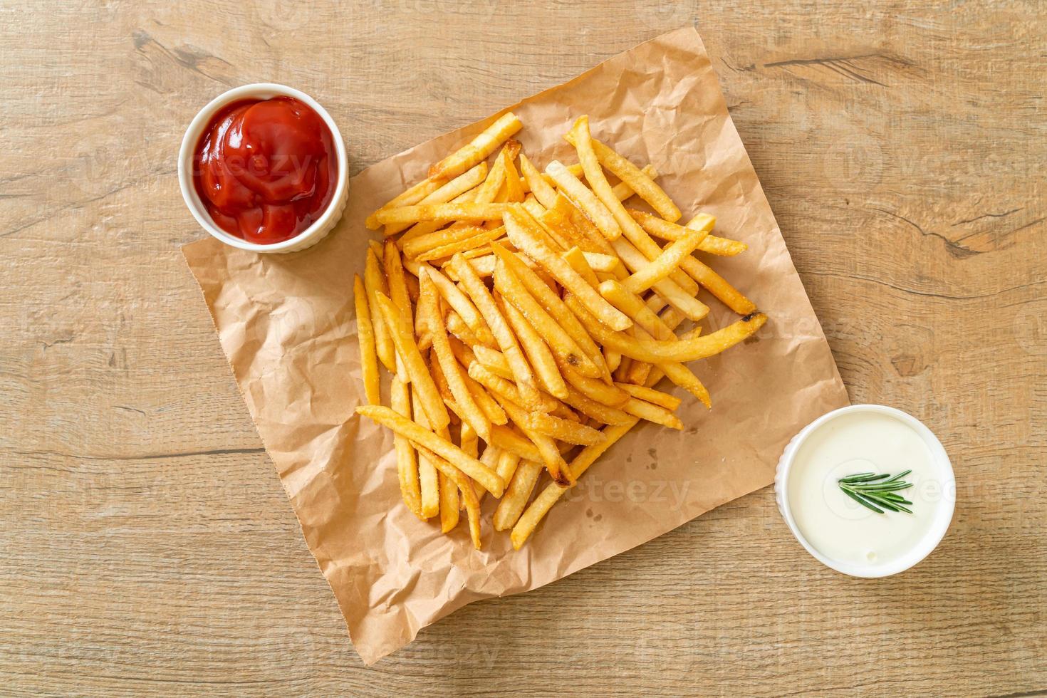 Pommes Frites mit Sauerrahm und Ketchup foto