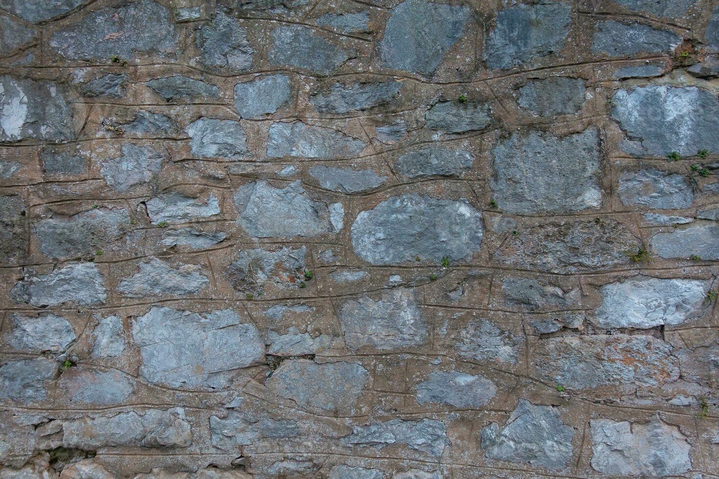 Stein Wände sind gemacht von enorm groß Ziegel mit Beton und Zement. robust Gebäude Struktur. texturiert Hintergrund mit Nahansicht Einzelheiten foto