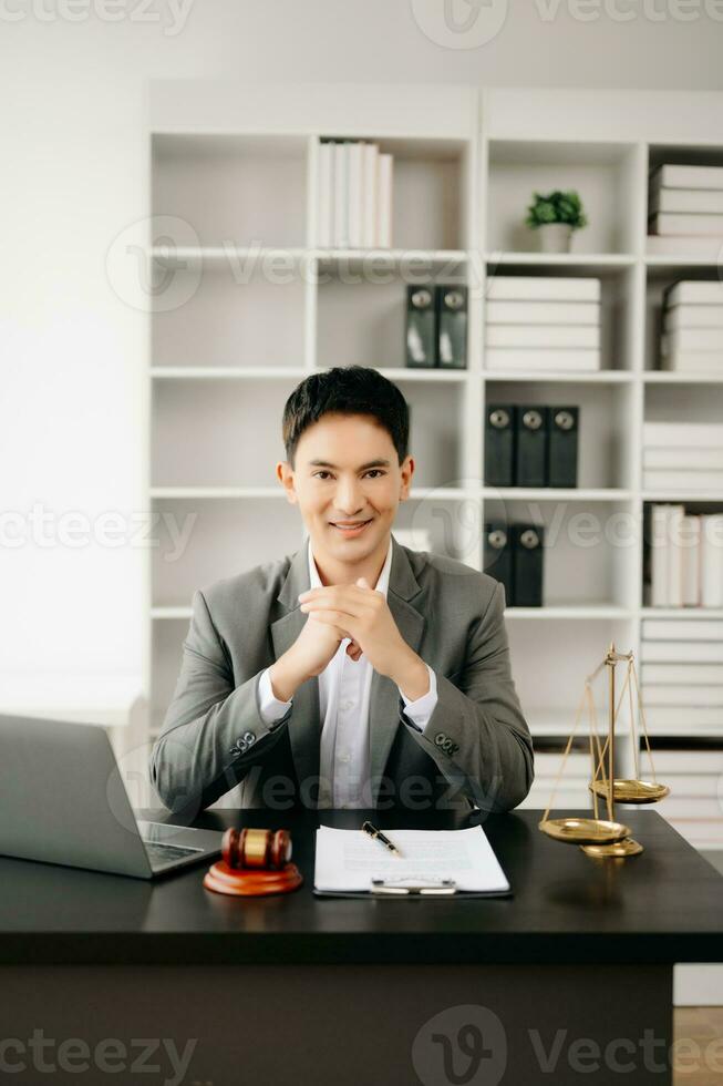 Gerechtigkeit und Gesetz Konzept .asiatisch männlich Richter im ein Gerichtssaal auf Tabelle und Berater Arbeiten im Büro. foto