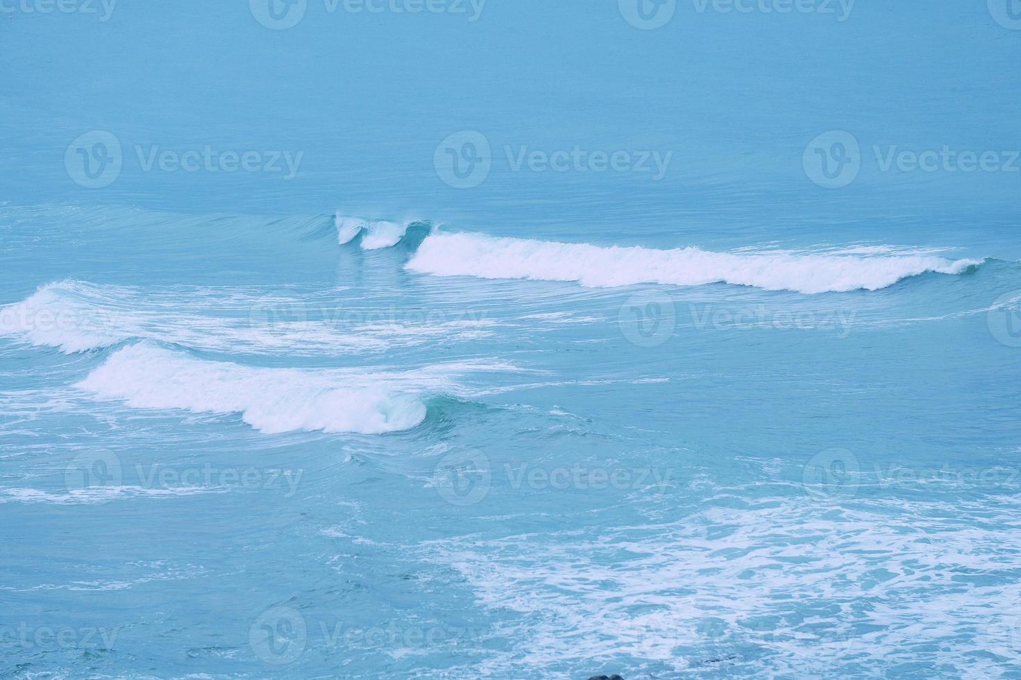 Wellen auf dem blauen Meer an der Küste foto