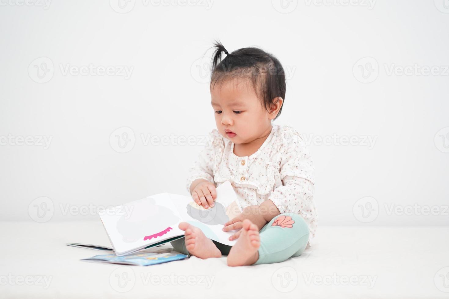 Porträt des asiatischen Babys, ein Märchenbuch lesend. foto