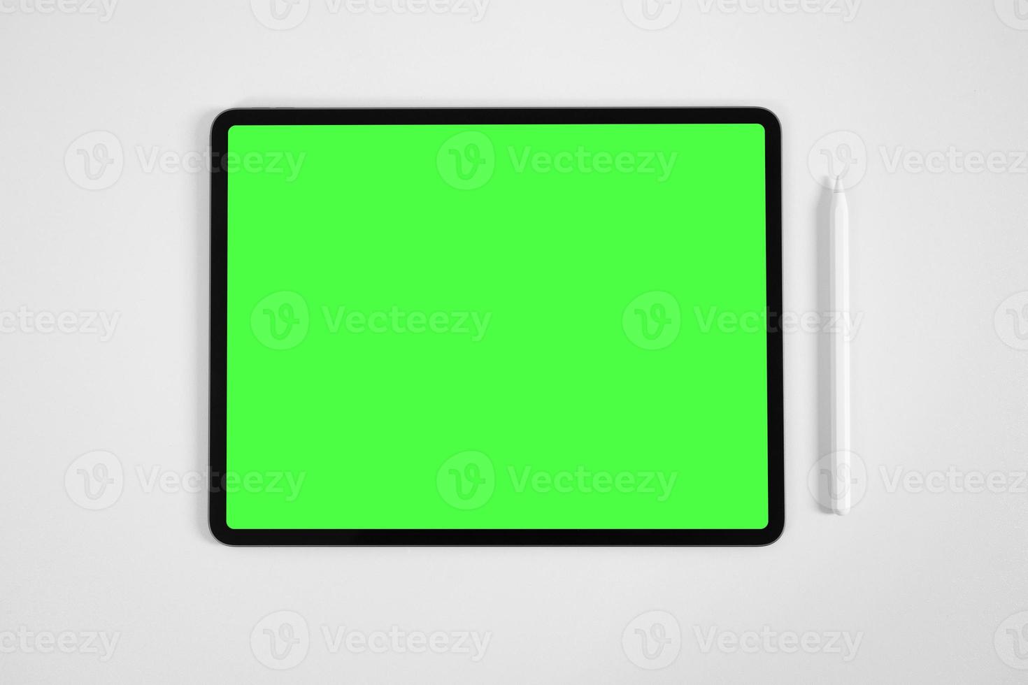 Mockup von Tablet und digitalem Bleistift mit vorgetastetem Greenscreen auf weißem Tisch foto