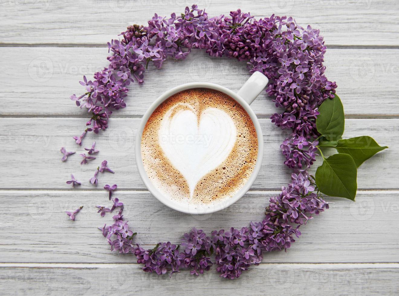 lila Blumen und eine Tasse Kaffee foto