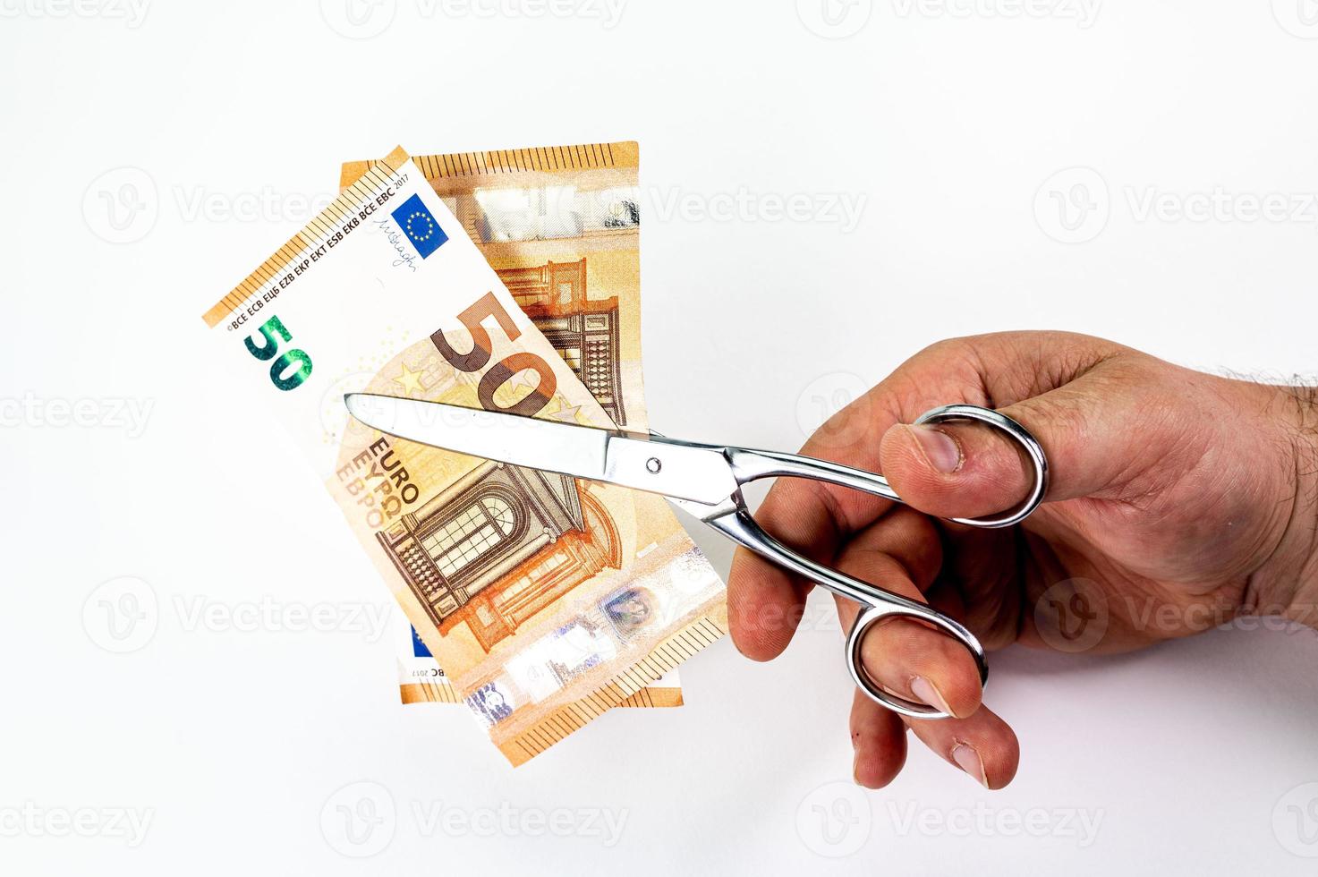 Mann schneidet 50-Euro-Banknoten mit einer Schere foto