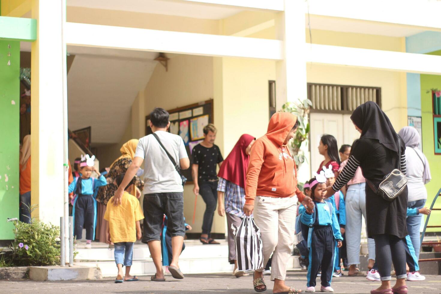 Magelang, Indonesien. 24 Juli 2023-Pflückung oben klein Kinder zu Kommen Sie Zuhause von Schule. foto