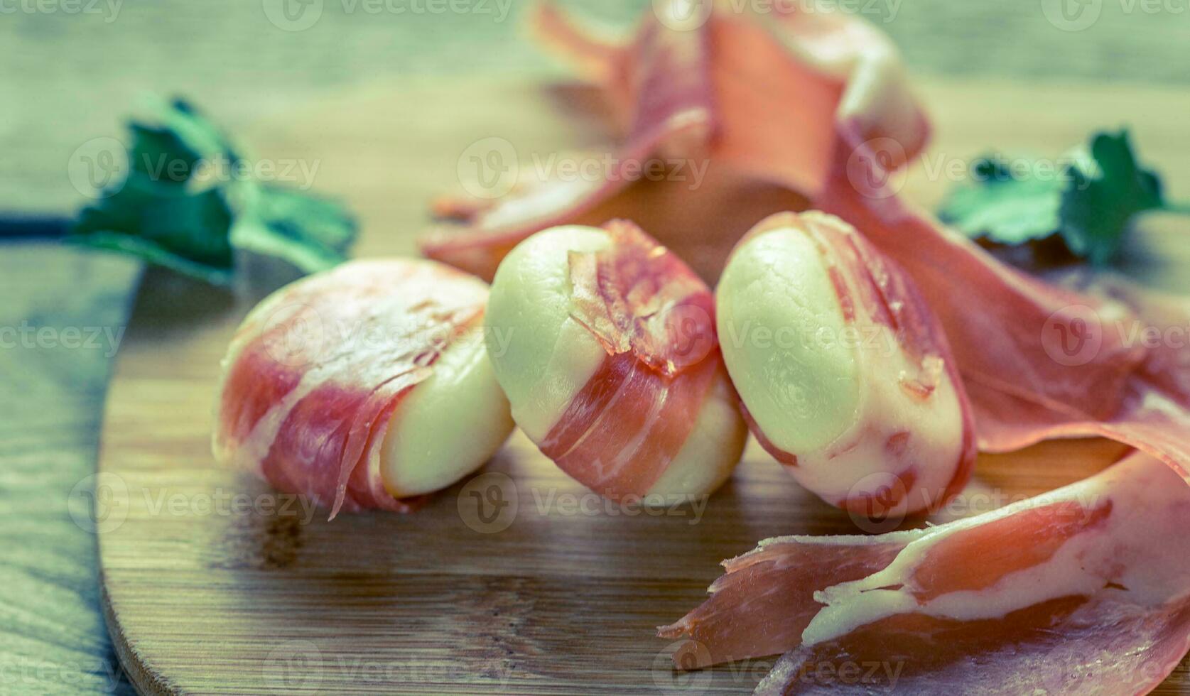 Mini Käse und Prosciutto Wraps auf das hölzern Tafel foto
