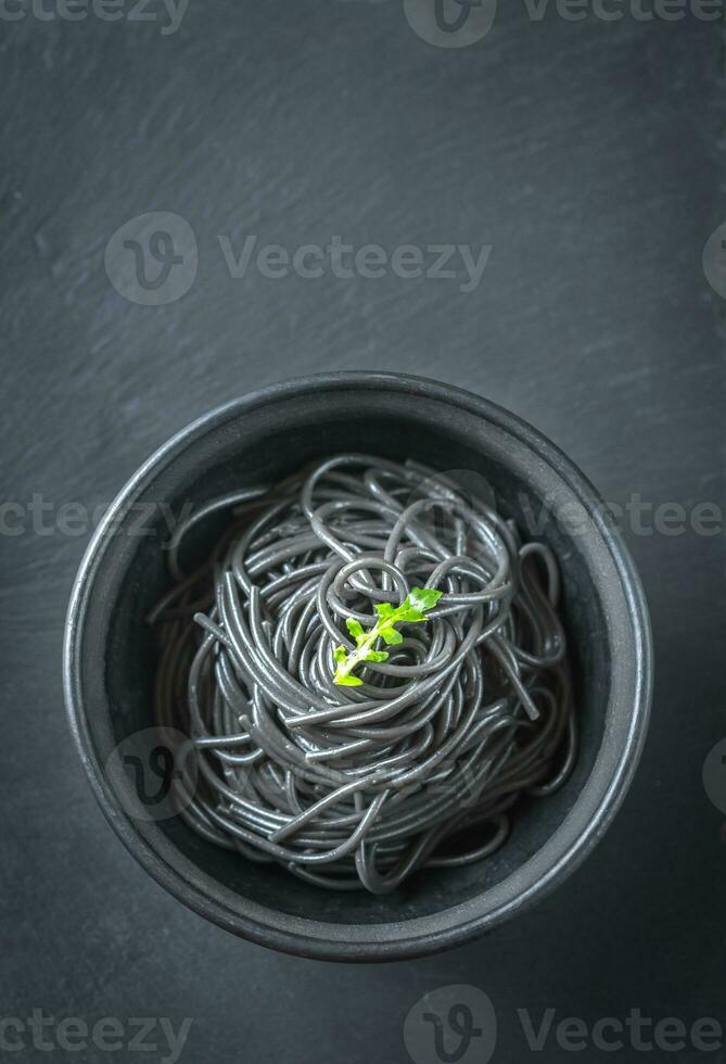 Schüssel von Pasta mit Tintenfisch Tinte mit Rucola Blatt foto