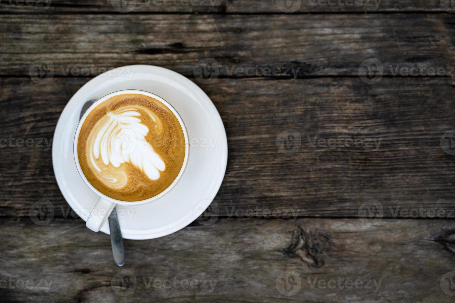 die Draufsicht auf eine Tasse Kaffee auf einem Holztisch foto