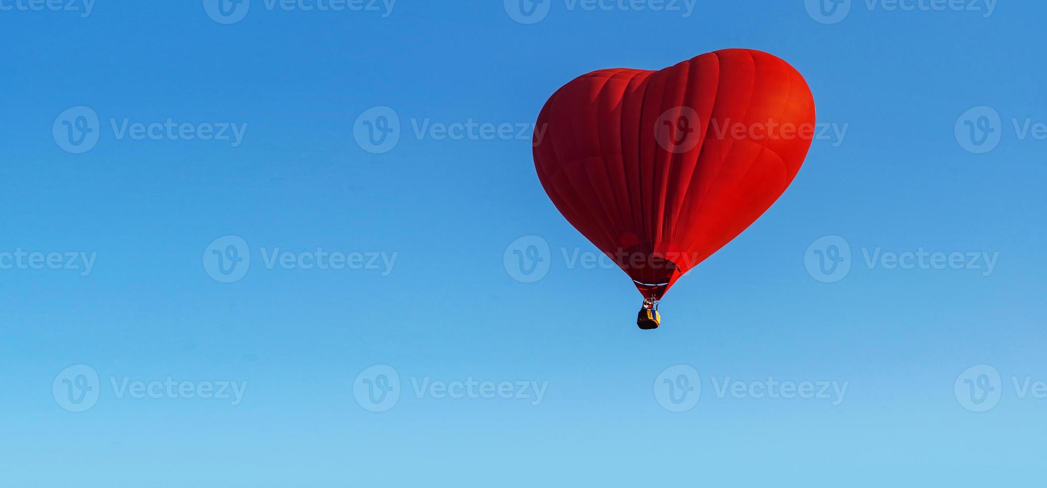 roter Herzballon am blauen Himmel foto