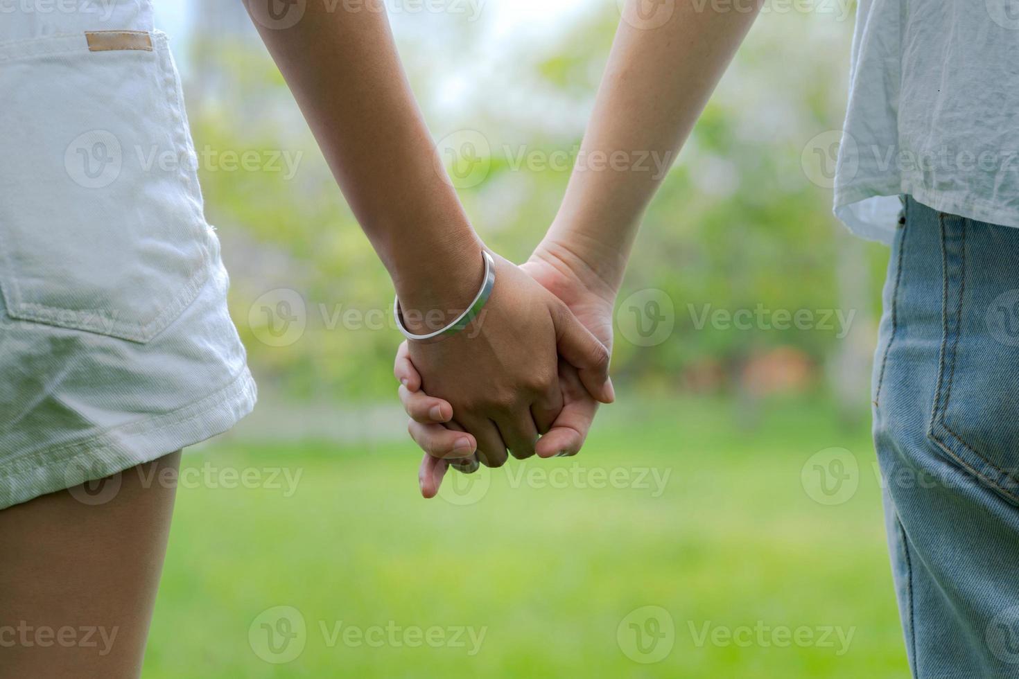 Paare, die Händchen halten im schönen Park foto