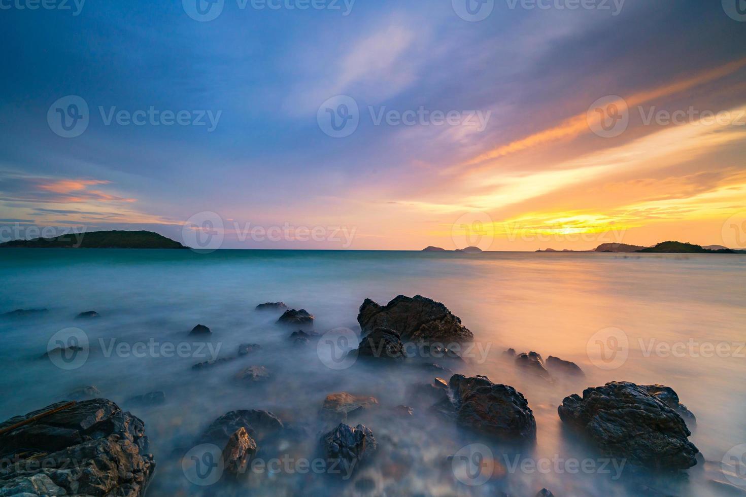 Langzeitbelichtung von Felsen am Meer bei Sonnenuntergang foto