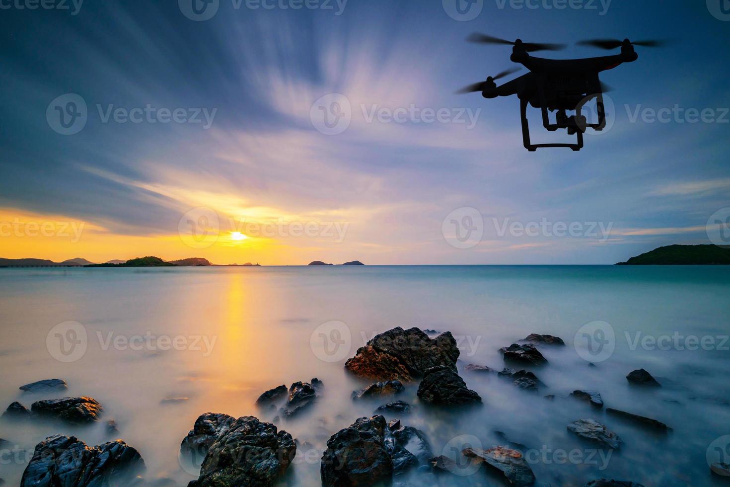 Silhouette einer Drohne, die über das Meer fliegt foto