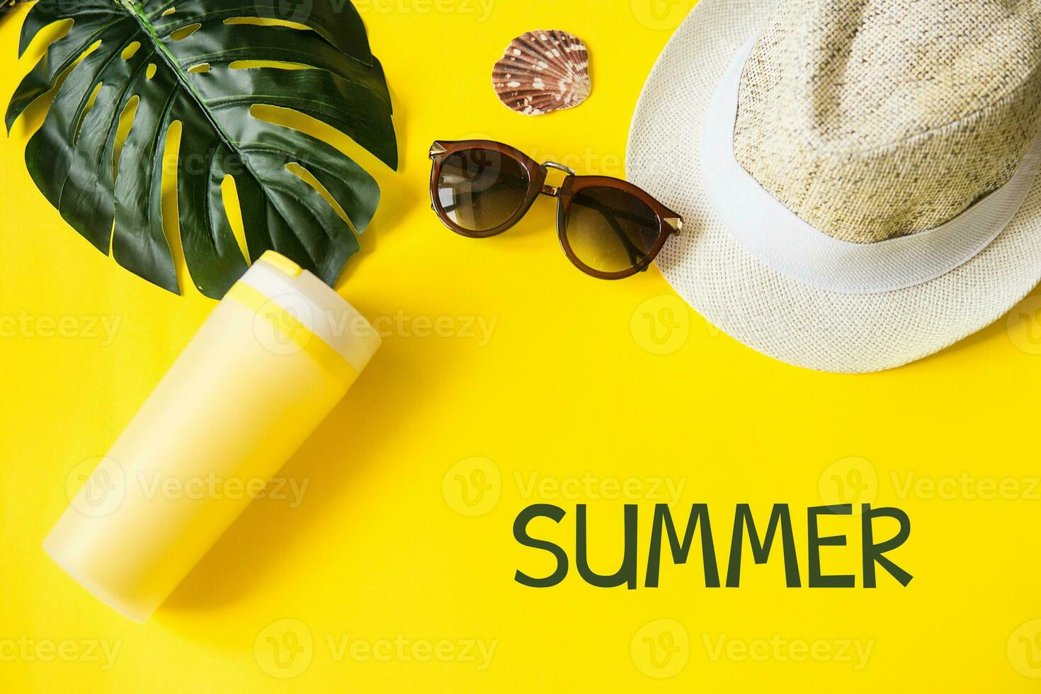 Strand Zubehör auf das Gelb Hintergrund - - Sonnenbrille und gestreift Hut. Sommer- ist Kommen Konzept.tropisch Blätter Monstera. Sommer- eben legen, oben Sicht. Text Sommer. foto