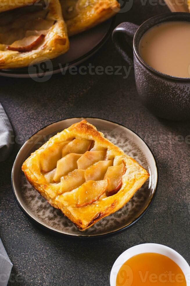 klein Kopf Nieder Puff Gebäck Kuchen mit Apfel auf ein Teller Vertikale Aussicht foto