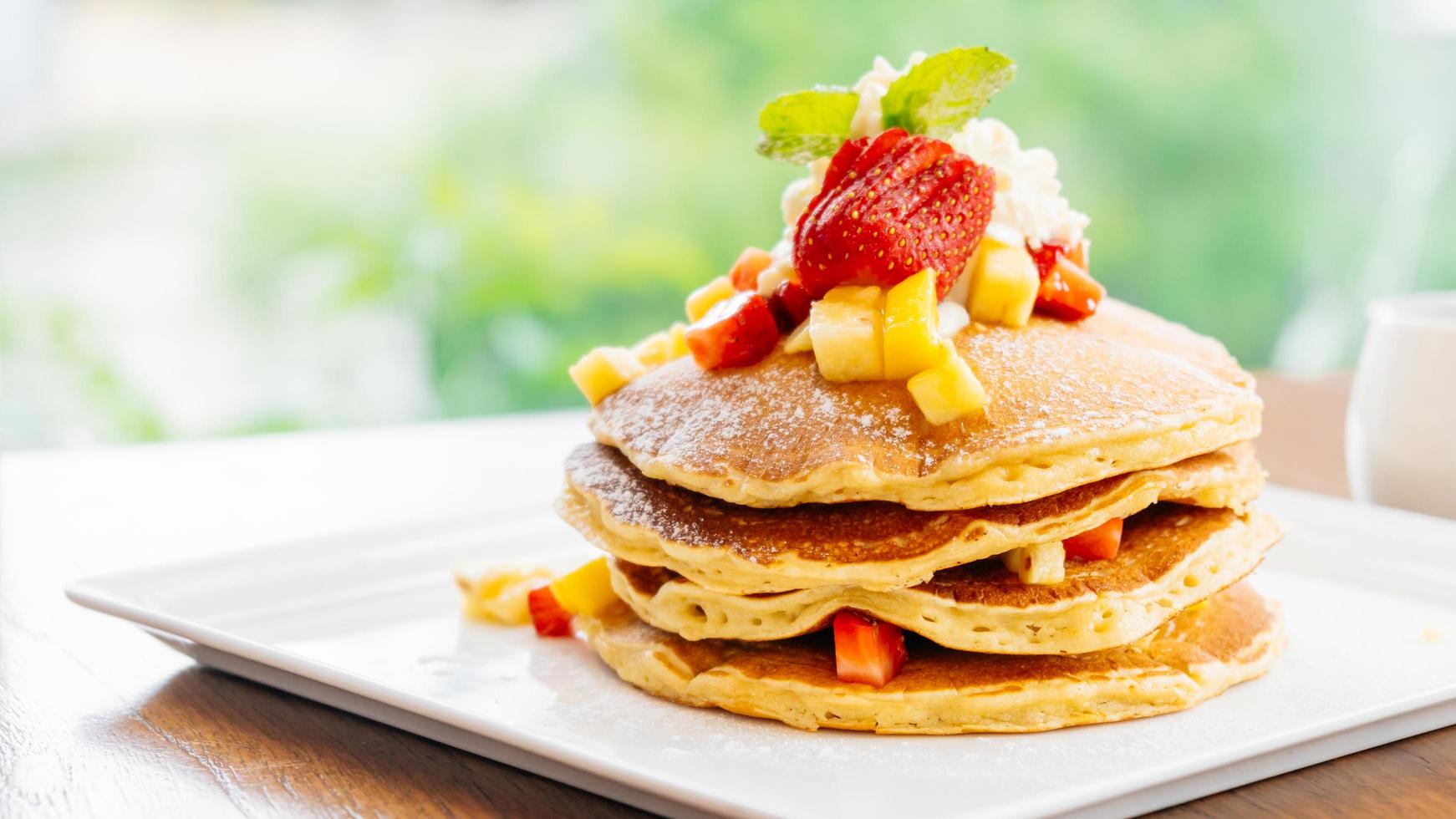 Stapel Pfannkuchen mit Erdbeere oben drauf foto