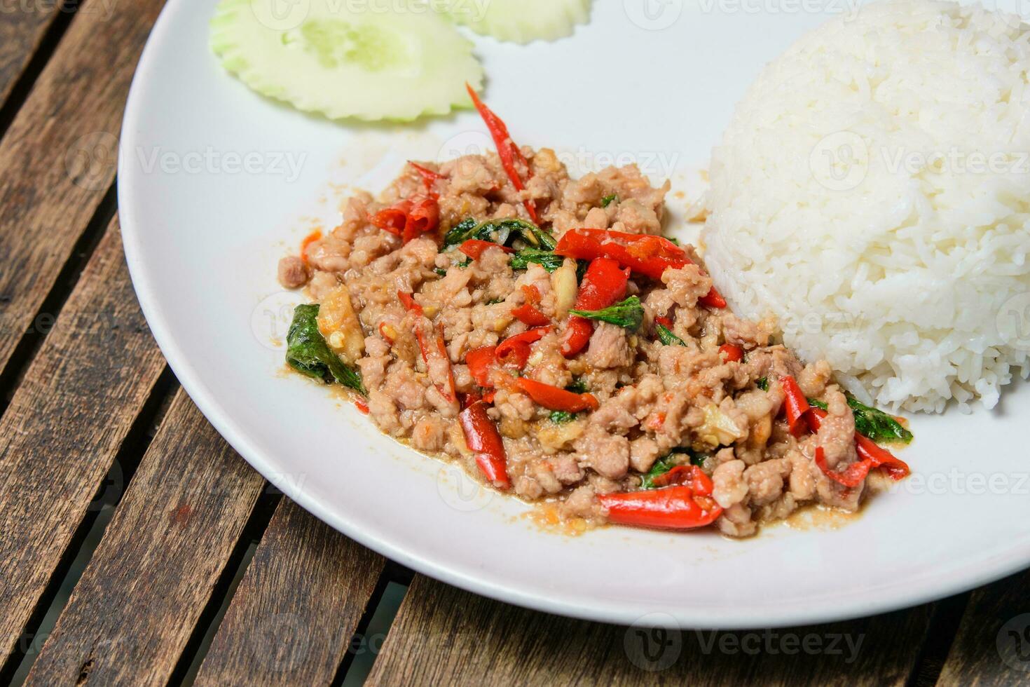 rühren gebraten thailändisch Basilikum mit gehackt Schweinefleisch auf das hölzern Hintergrund. Liebling Essen von Thailand Pad Gaprao. foto