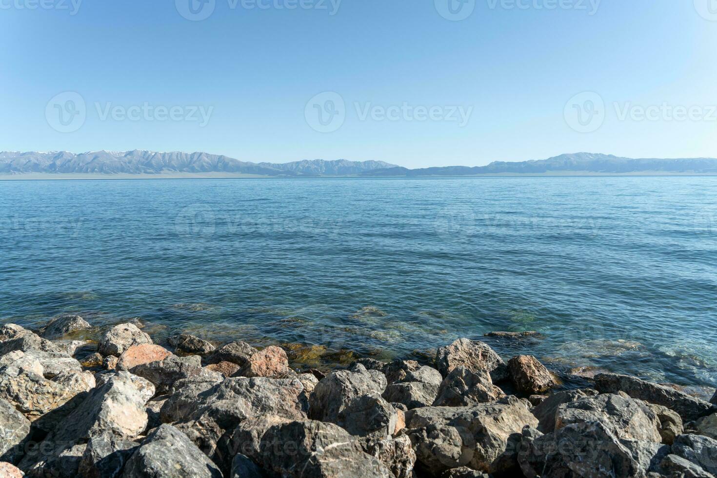 das Ruhe Oberfläche von das See und Felsen. Schuss im Sayram See im Xinjiang, China. foto