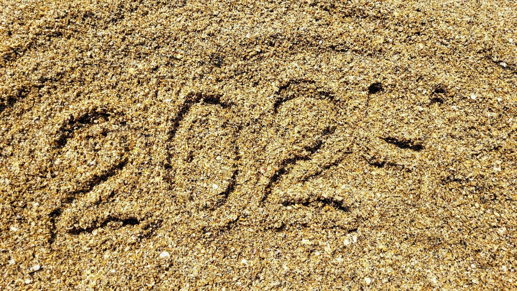 das Zahlen 2024 sind geschrieben auf das sandig Strand. das Konzept von das Neu Jahr foto