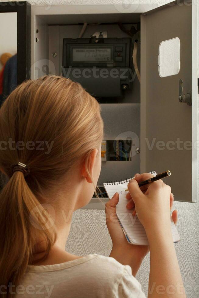 jung Frau schreibt um das elektrisch Meter Lesungen foto