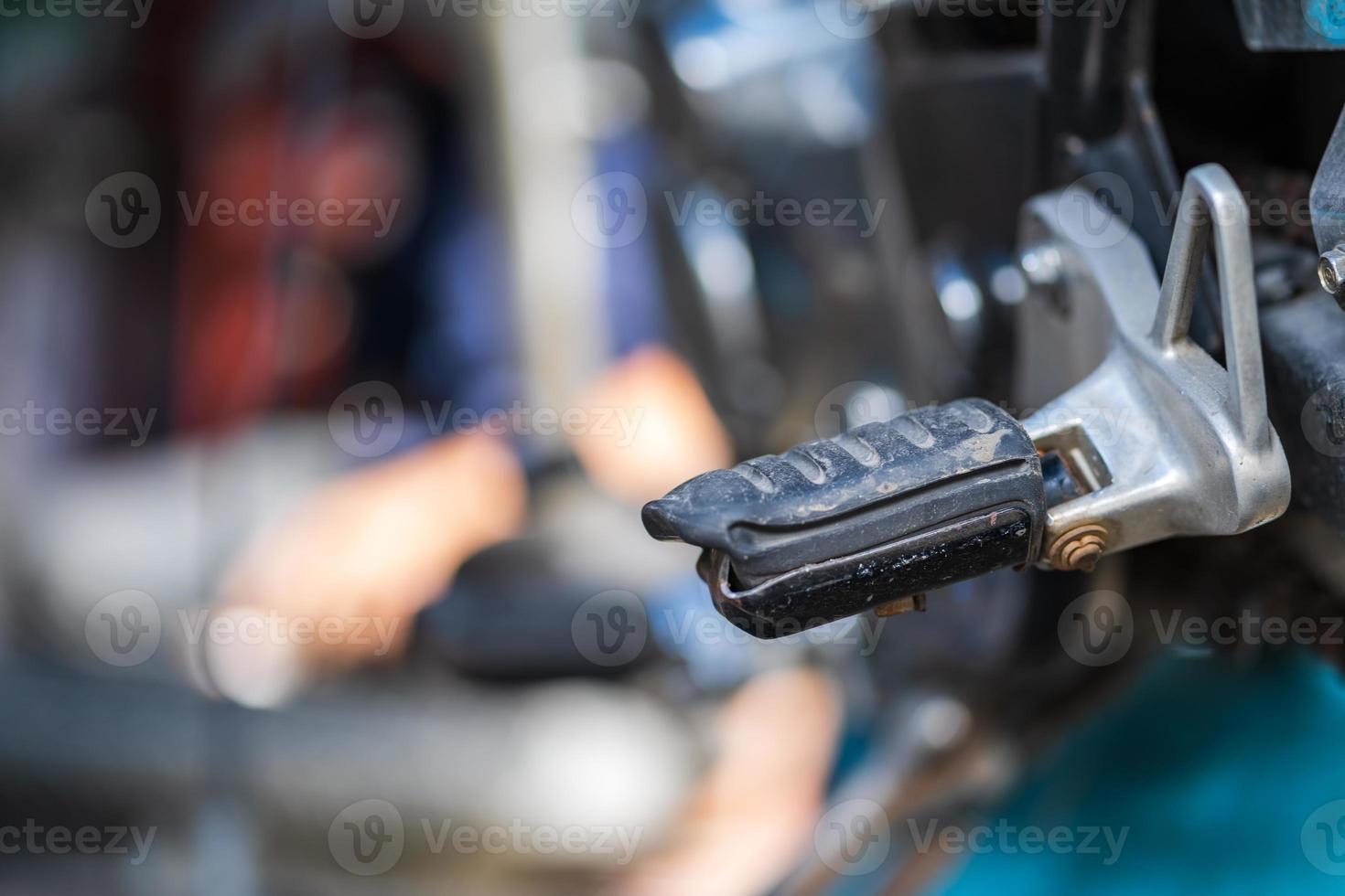 Kfz-Mechaniker, der Motorrad in Fahrradreparaturwerkstatt repariert foto