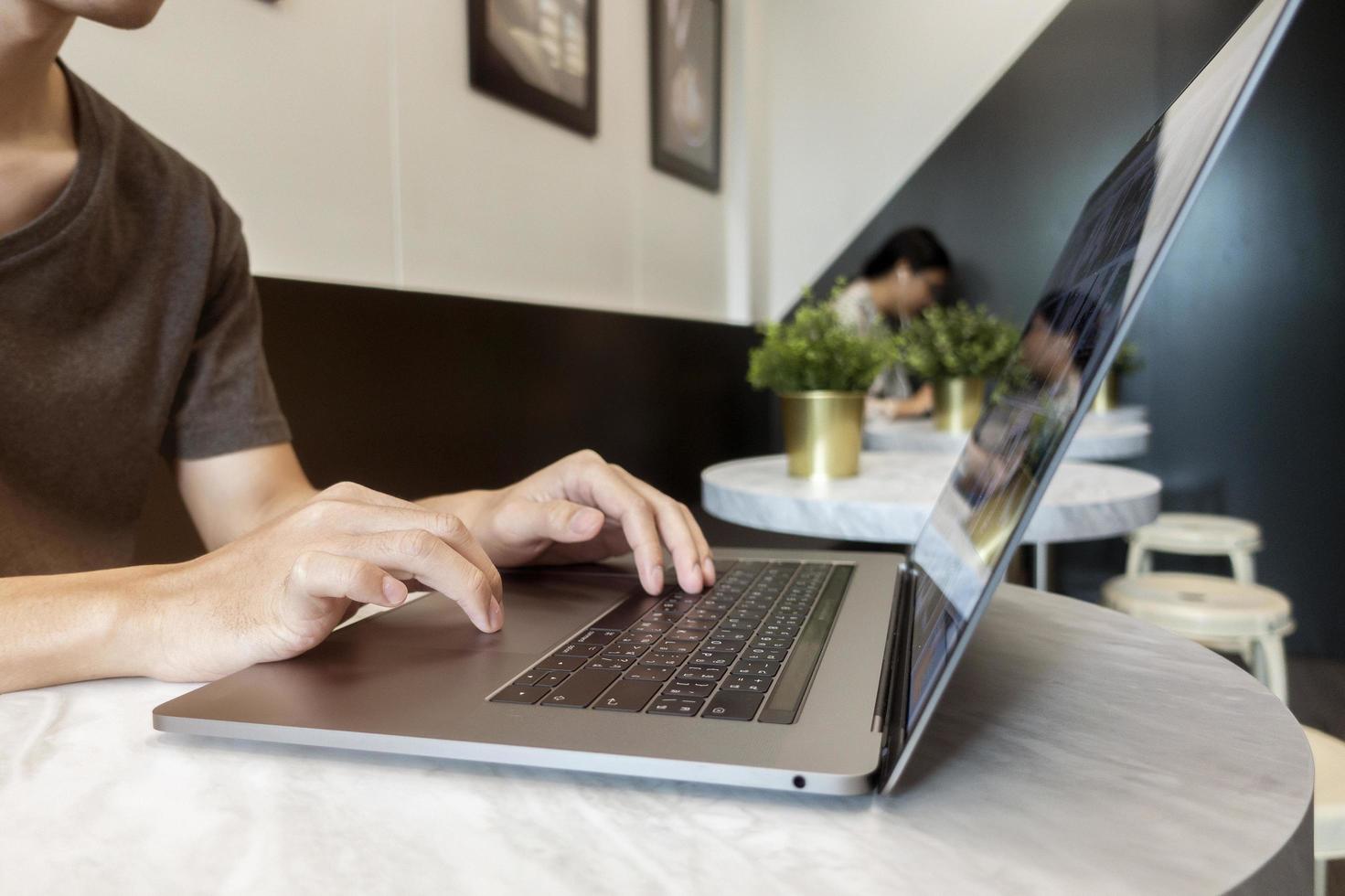 Nahaufnahme der Hand des Mannes, die im Café am Laptop arbeitet? foto