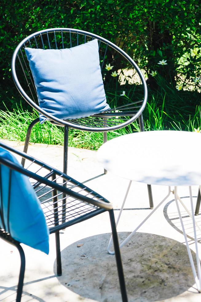 Terrasse mit Kissen auf Stuhl und Tischgarnitur foto