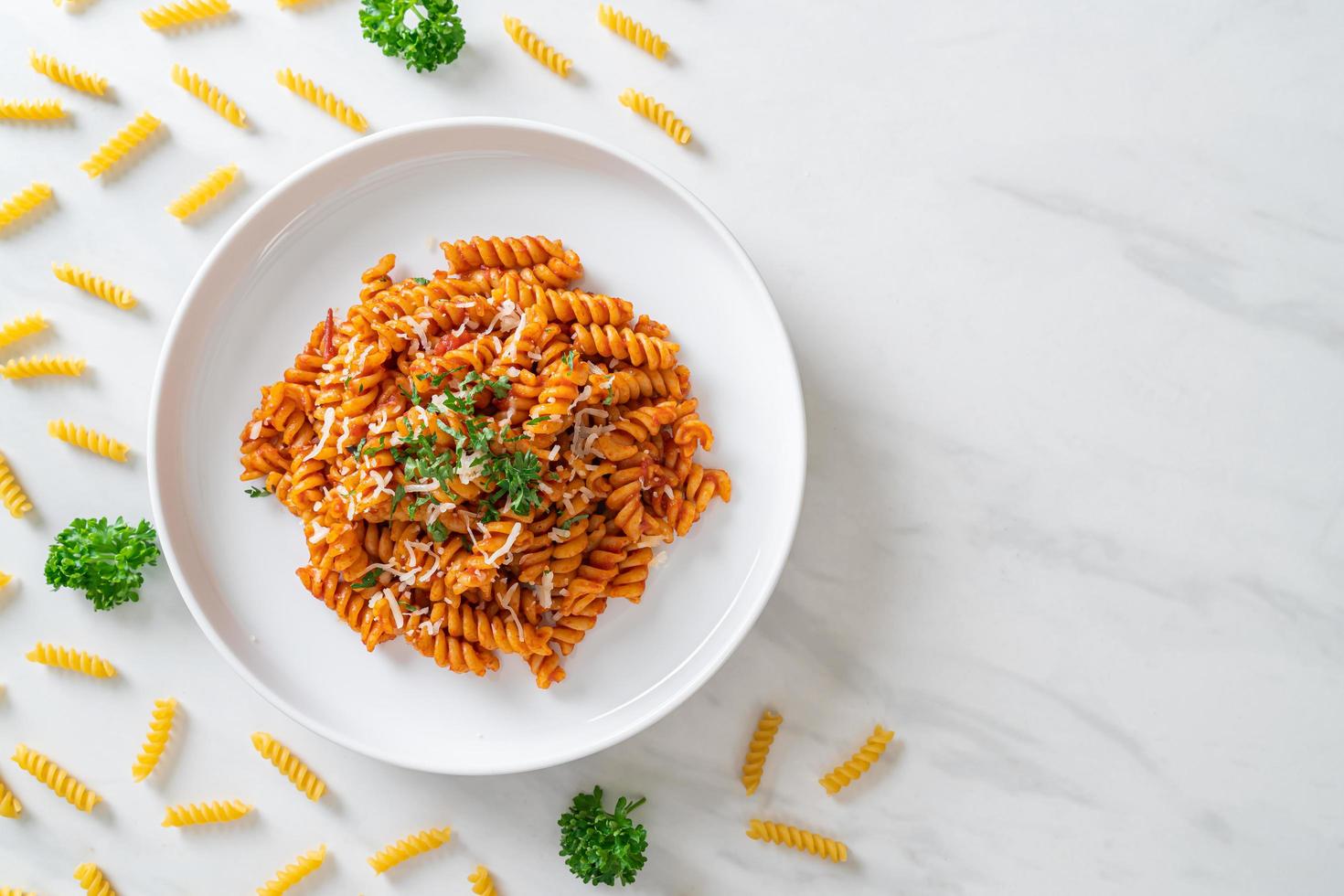 Spiral- oder Spirali-Nudeln mit Tomatensauce und Wurst - italienische Küche foto