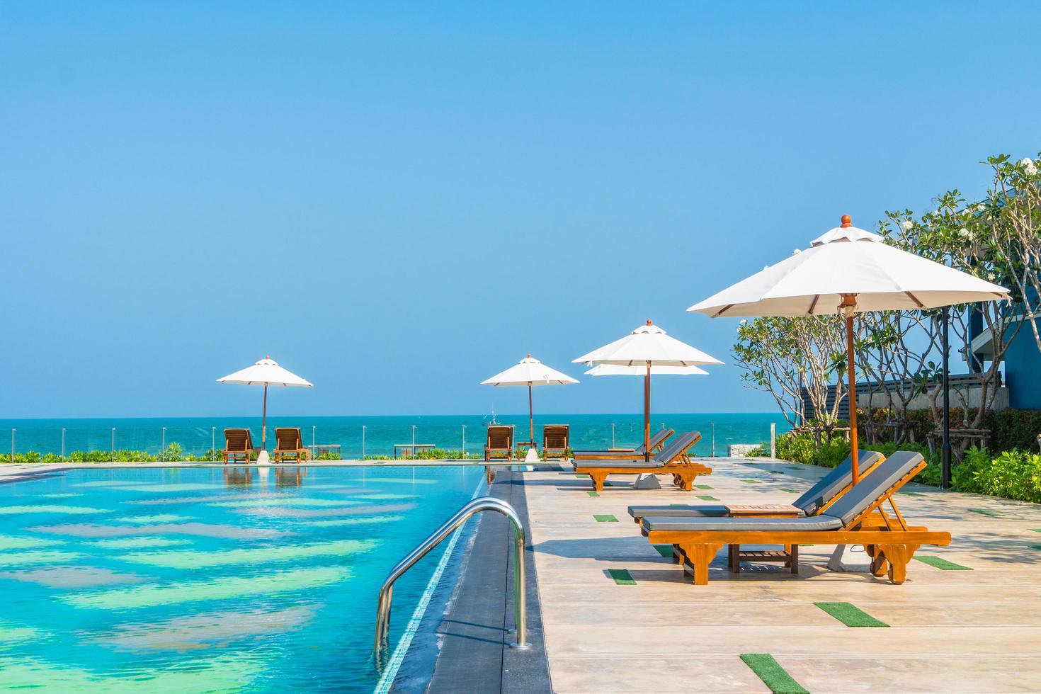 schöner Sonnenschirm und Stuhl um den Pool im Hotel und Resort? foto