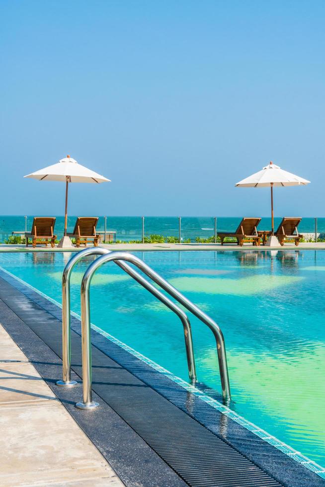 schöner Sonnenschirm und Stuhl um den Pool im Hotel und Resort? foto