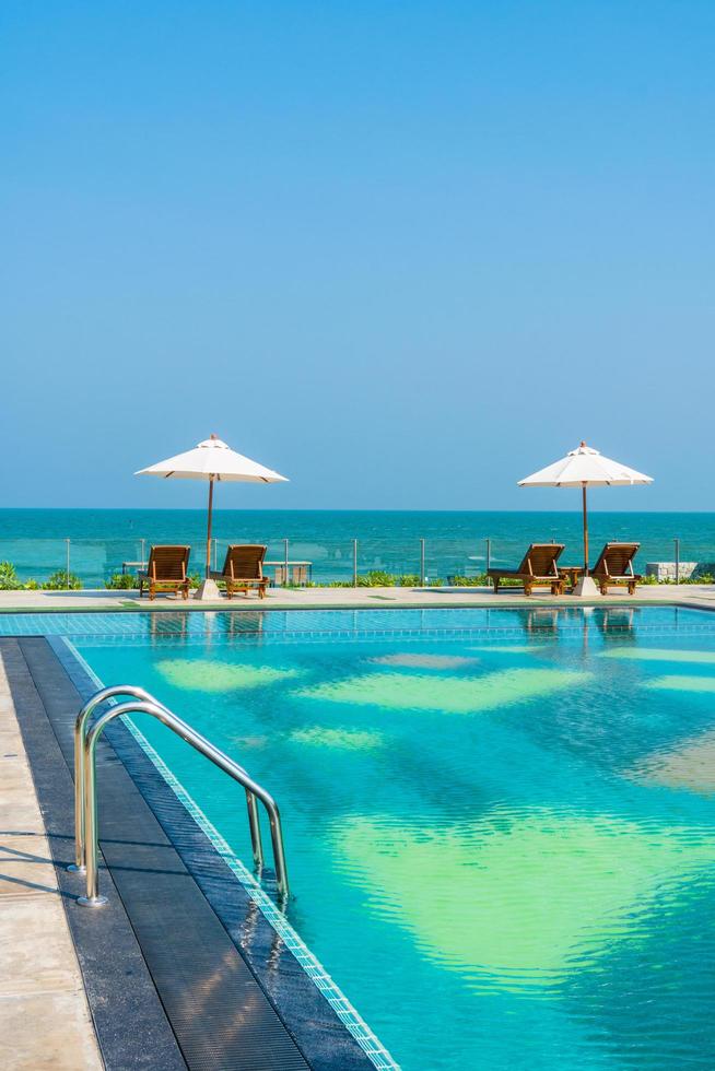 schöner Sonnenschirm und Stuhl um den Pool im Hotel und Resort? foto