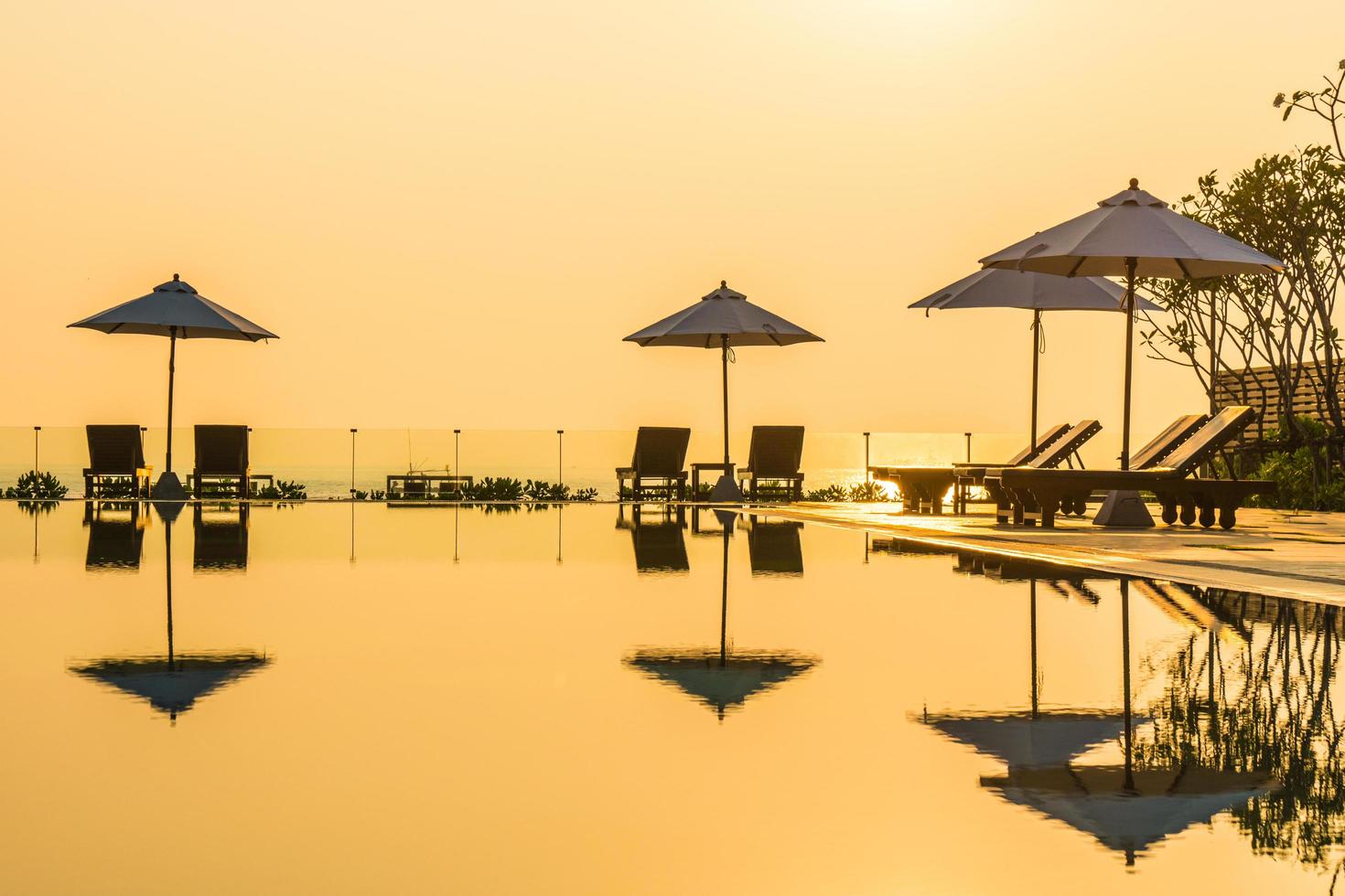 schöner Sonnenschirm und Stuhl um den Pool im Hotel und Resort? foto