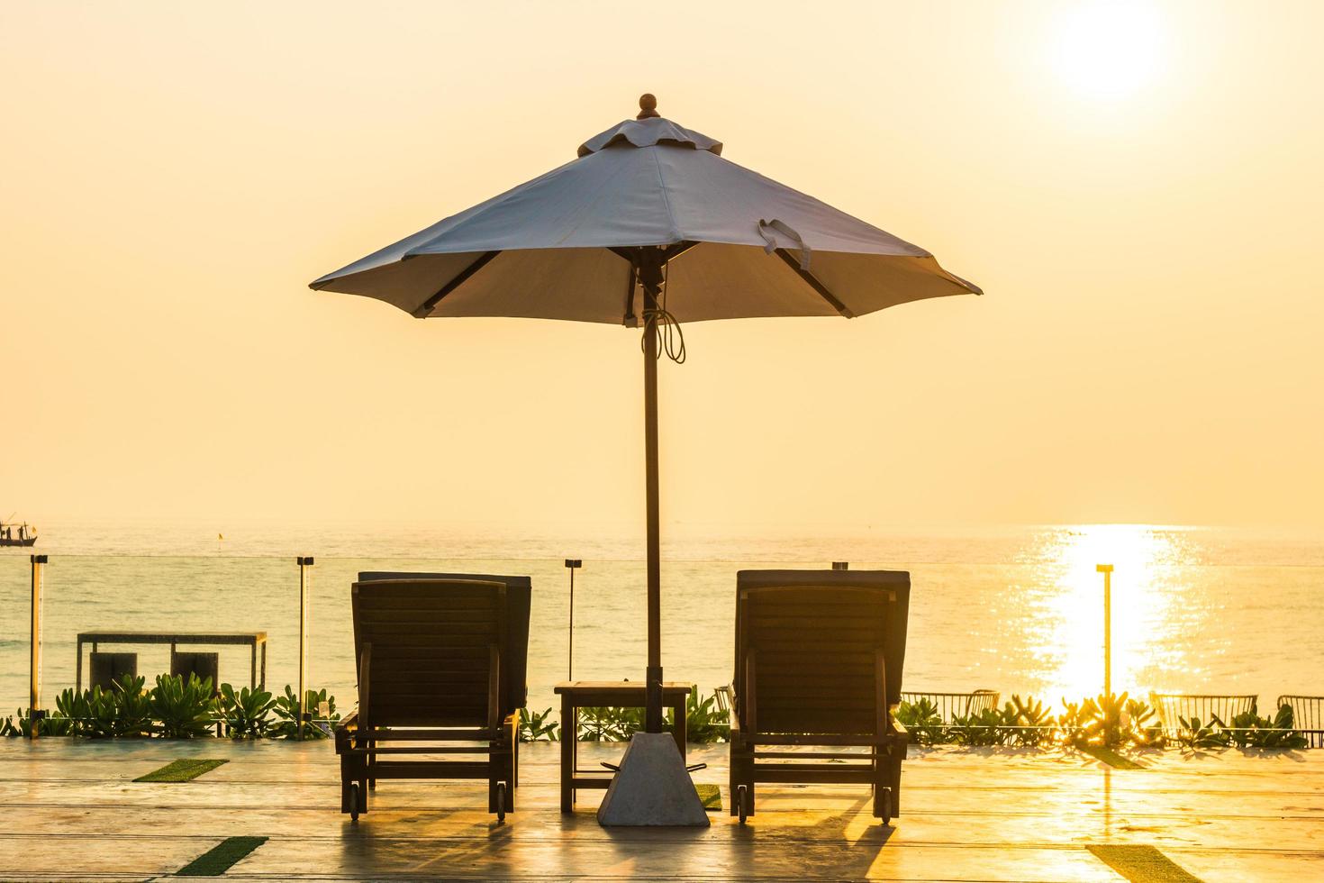 schöner Sonnenschirm und Stuhl um den Pool im Hotel und Resort? foto