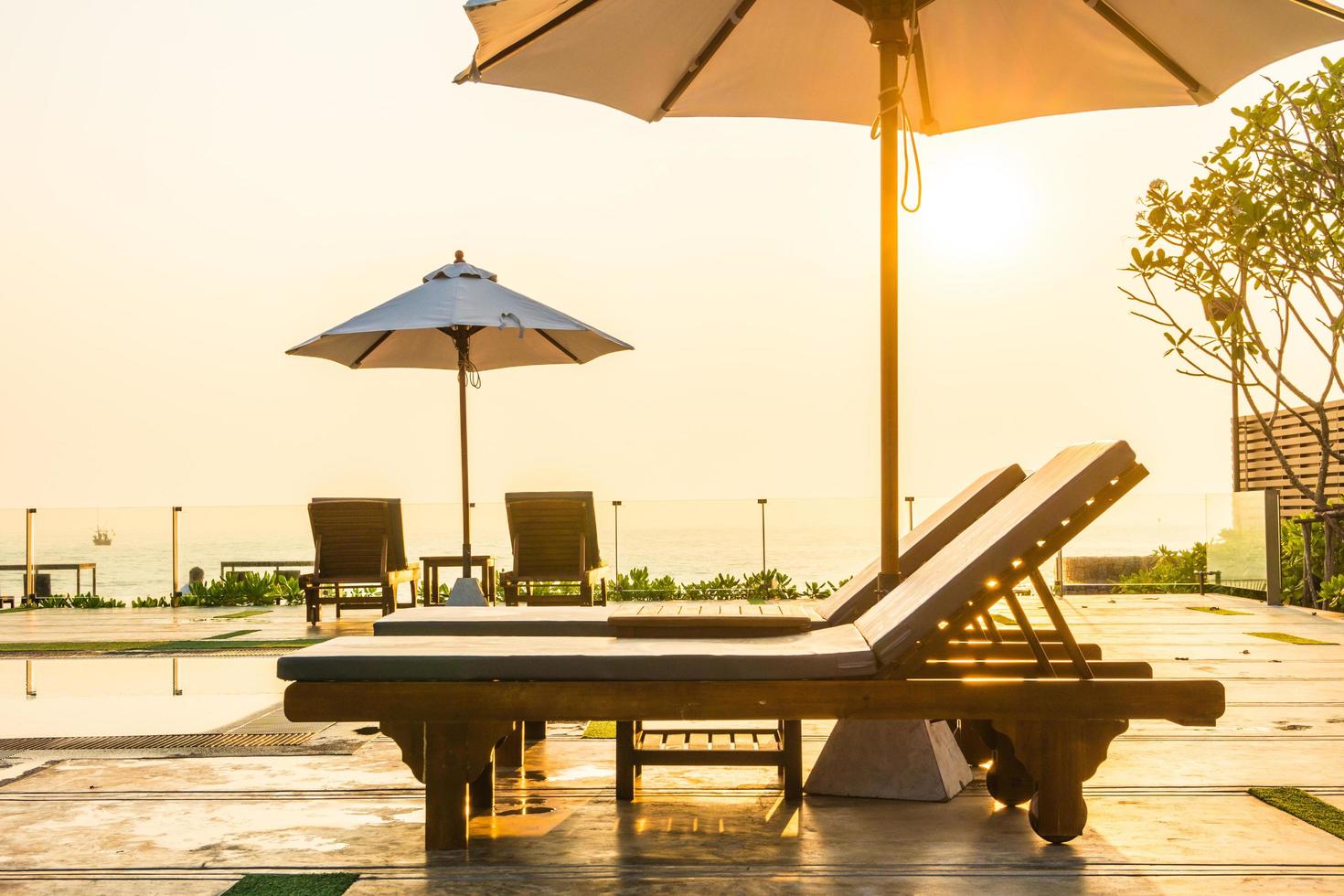 schöner Sonnenschirm und Stuhl um den Pool im Hotel und Resort? foto