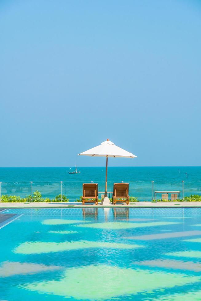 schöner Sonnenschirm und Stuhl um den Pool im Hotel und Resort? foto