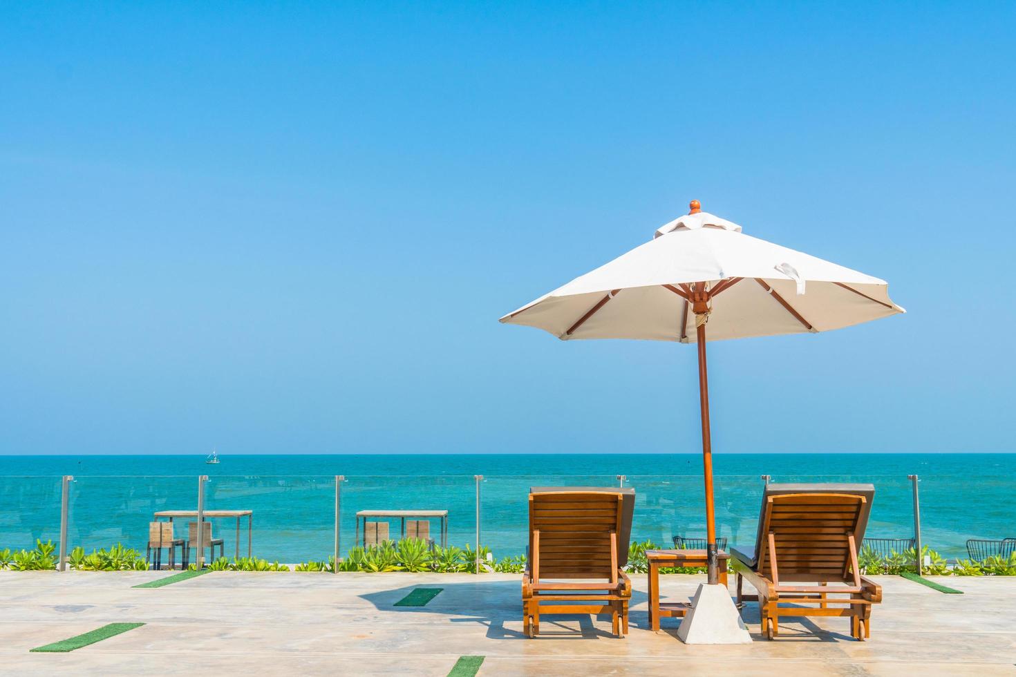 schöner Sonnenschirm und Stuhl um den Pool im Hotel und Resort? foto