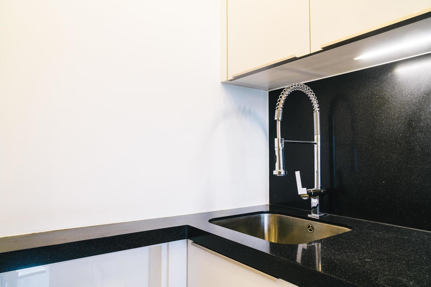 Wasserhahn- und Spülendekoration im Küchenraum foto