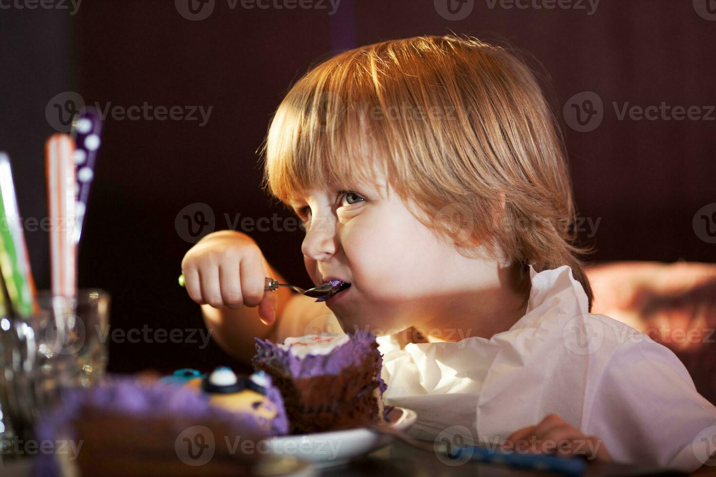wenig Junge Essen Schokolade Kuchen foto