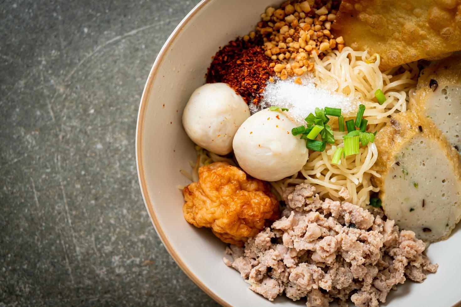 scharfe Eiernudeln mit Fischbällchen und Garnelenbällchen ohne Suppe - asiatische Küche foto