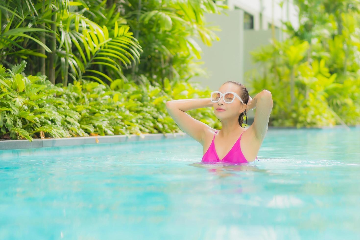 Porträt schöne junge asiatische Frau entspannen Lächeln um den Außenpool im Hotelresort? foto