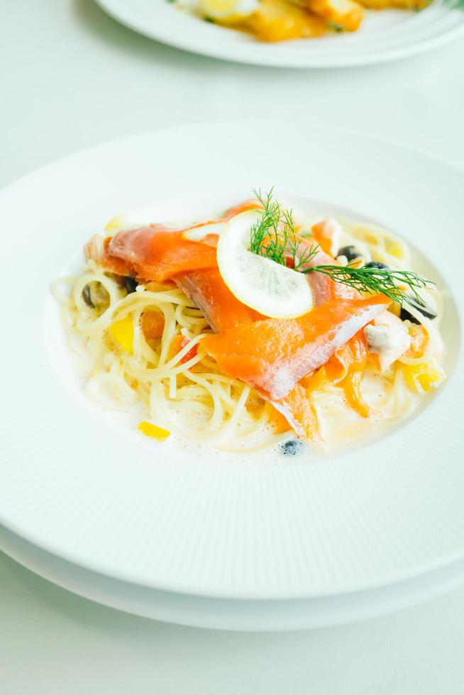 Pasta oder Spaghetti-Sahnesauce mit Lachsfleisch und Zitrone darüber on foto