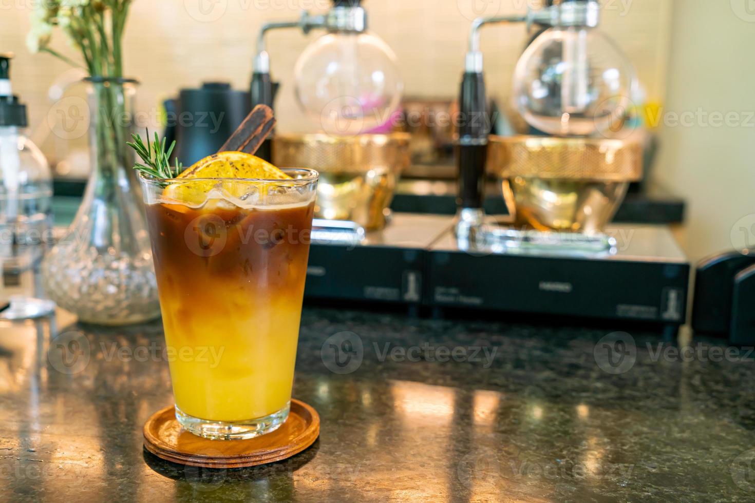 Orangen- und Zitronensaft-Soda mit schwarzem Kaffee im Glas mit Rosmarin und Zimt foto