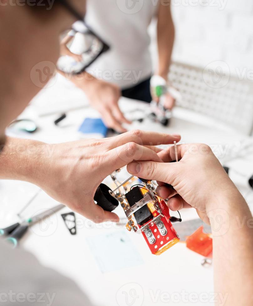 Jungen, die Spaß daran haben, Roboterautos in der Werkstatt zu bauen foto