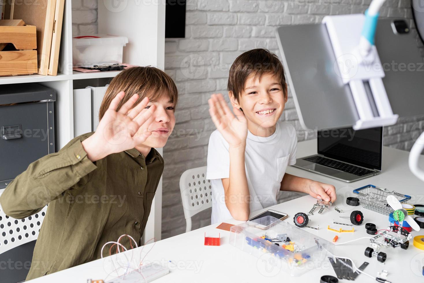 Jungen, die Spaß daran haben, Roboterautos zu bauen, die Online-Kurse auf einem digitalen Tablet haben foto