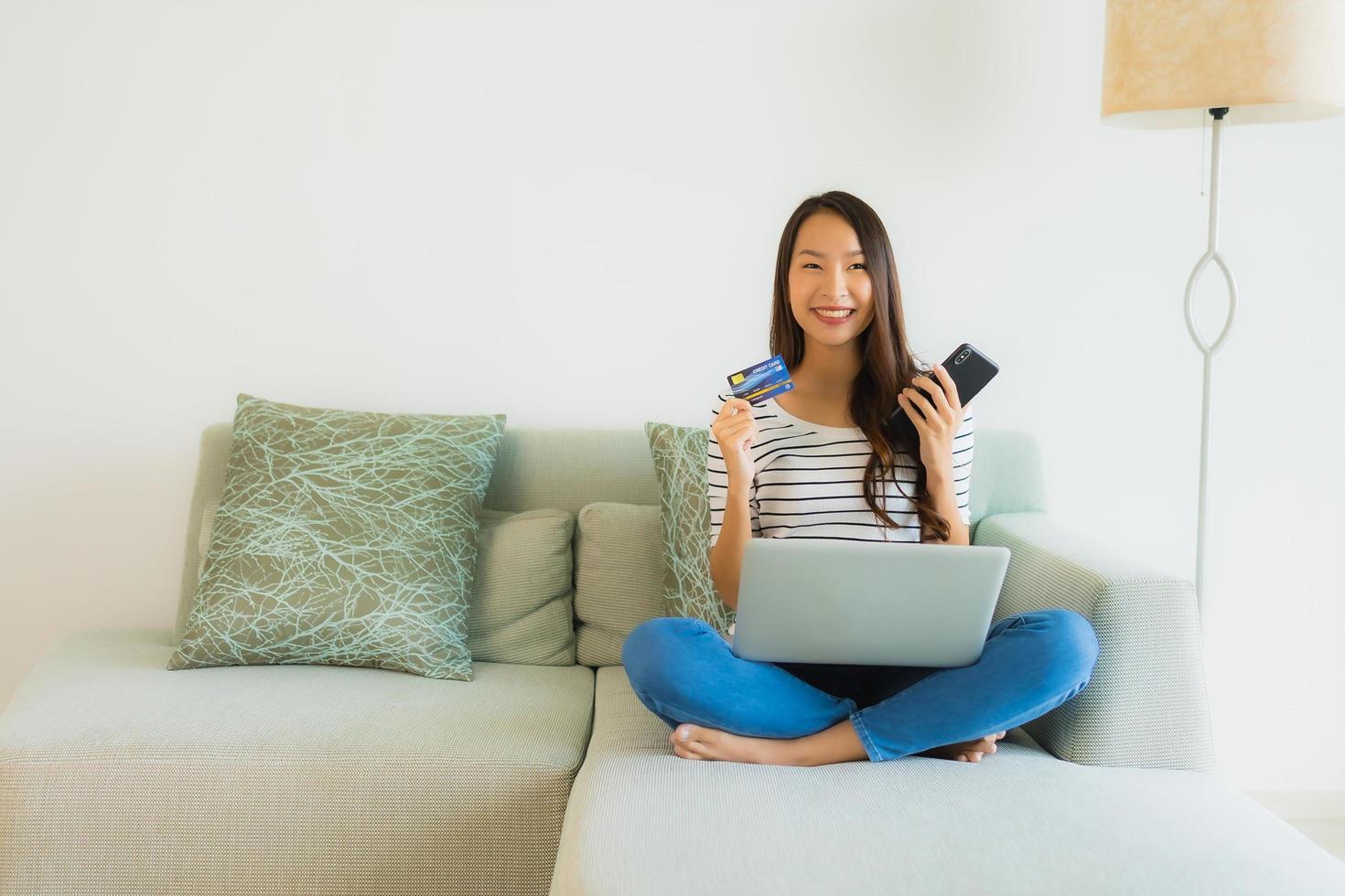 Porträt schöne junge asiatische Frauen mit Kreditkarten-Handy oder Computer zum Einkaufen foto