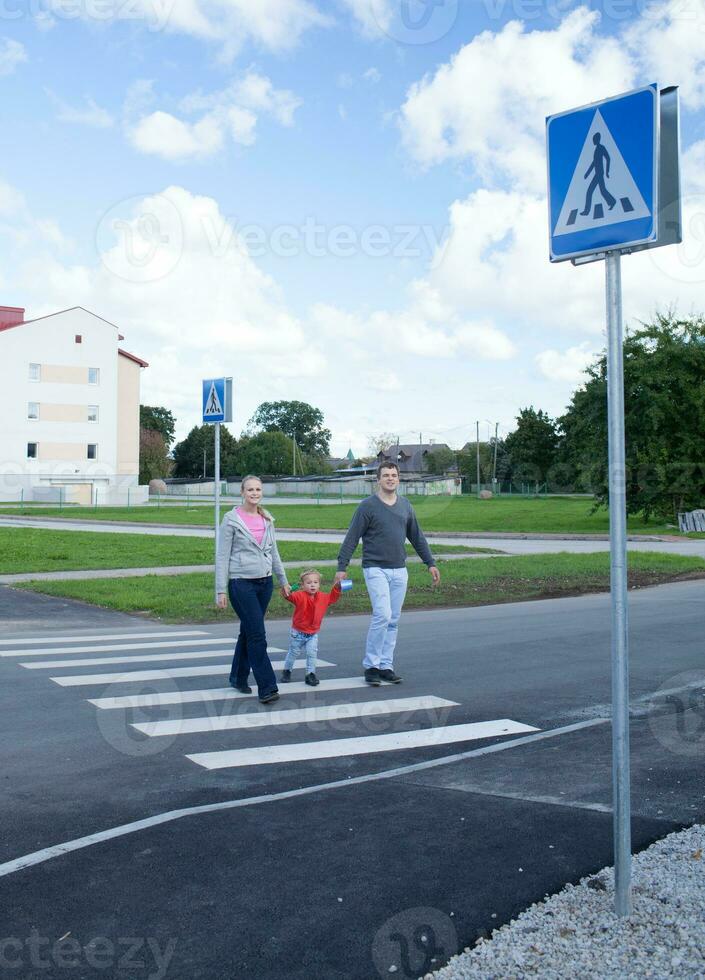 Familie von drei Kreuzung das Straße. foto