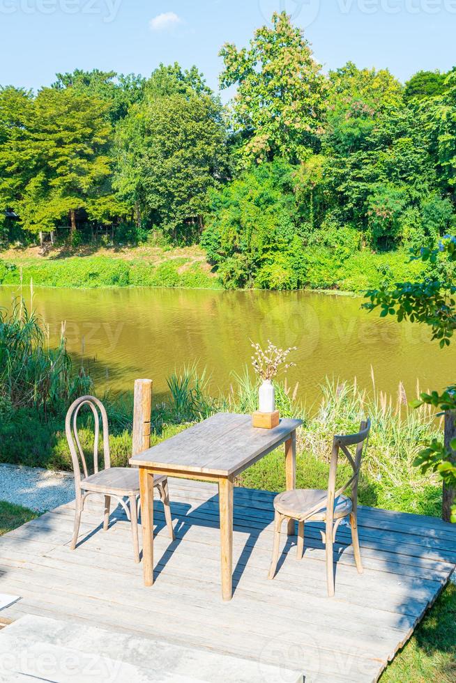 leerer Tisch und Stuhl mit Blick auf den Fluss und blauem Himmel foto