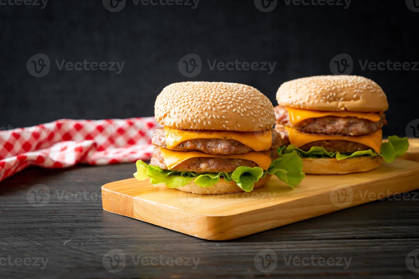 Schweine-Hamburger oder Schweine-Burger mit Käse auf Holzbrett foto