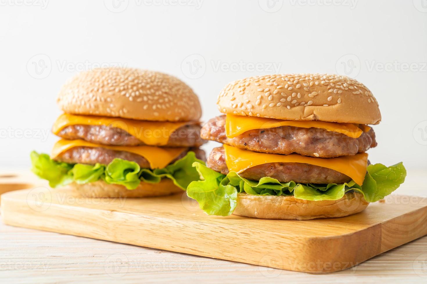 Schweine-Hamburger oder Schweine-Burger mit Käse auf Holzbrett foto